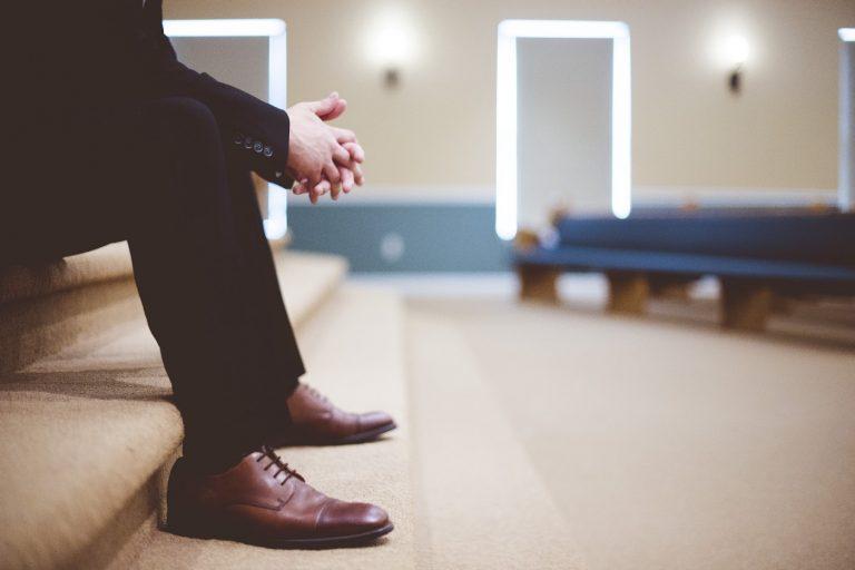 Man sitting on steps of an empty church